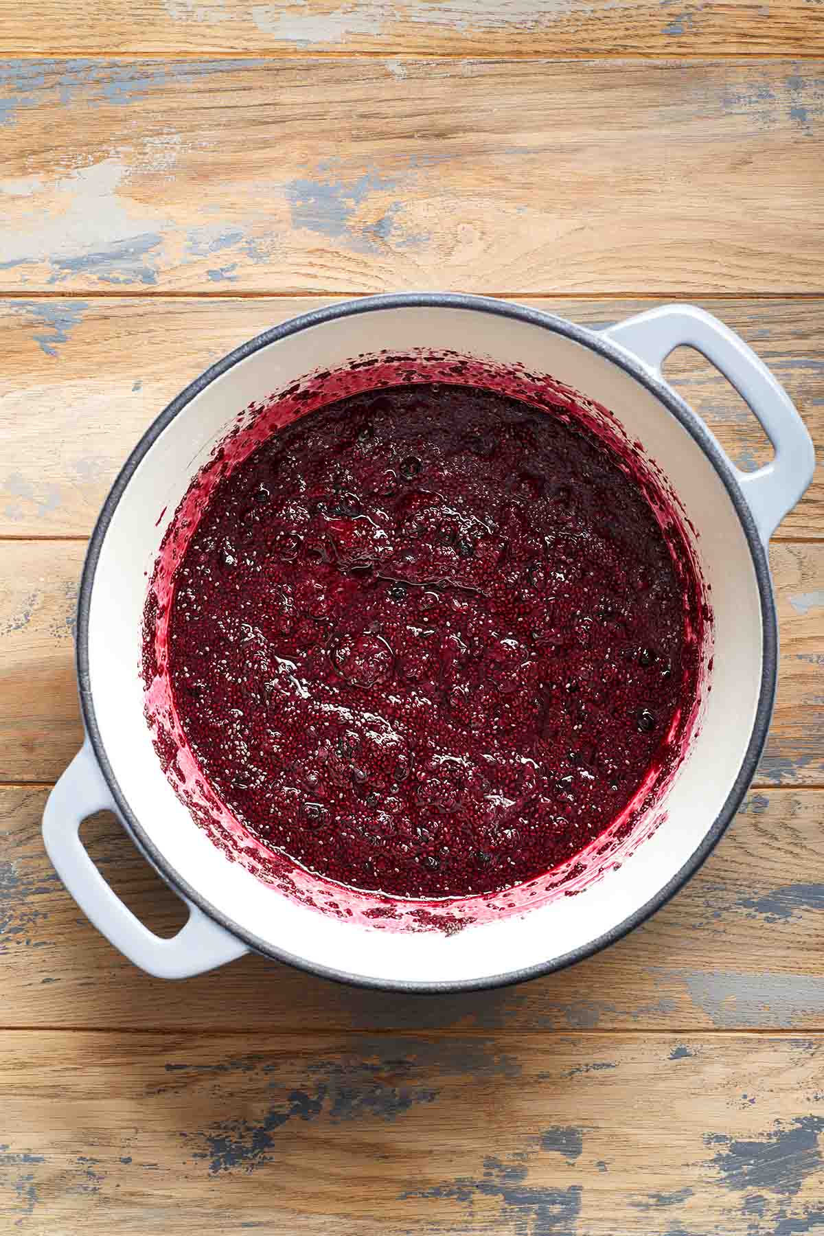 Mashed berries mixed with chia seeds in a pot.