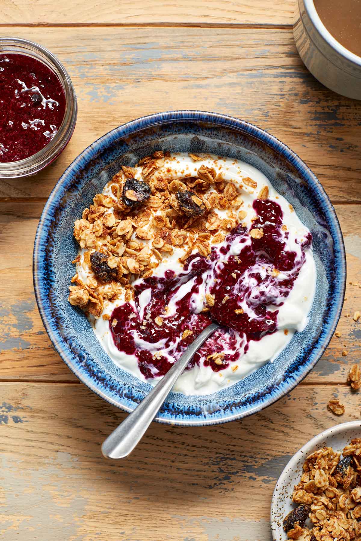 A bowl of yogurt topped with granola and swirled with chia jam.