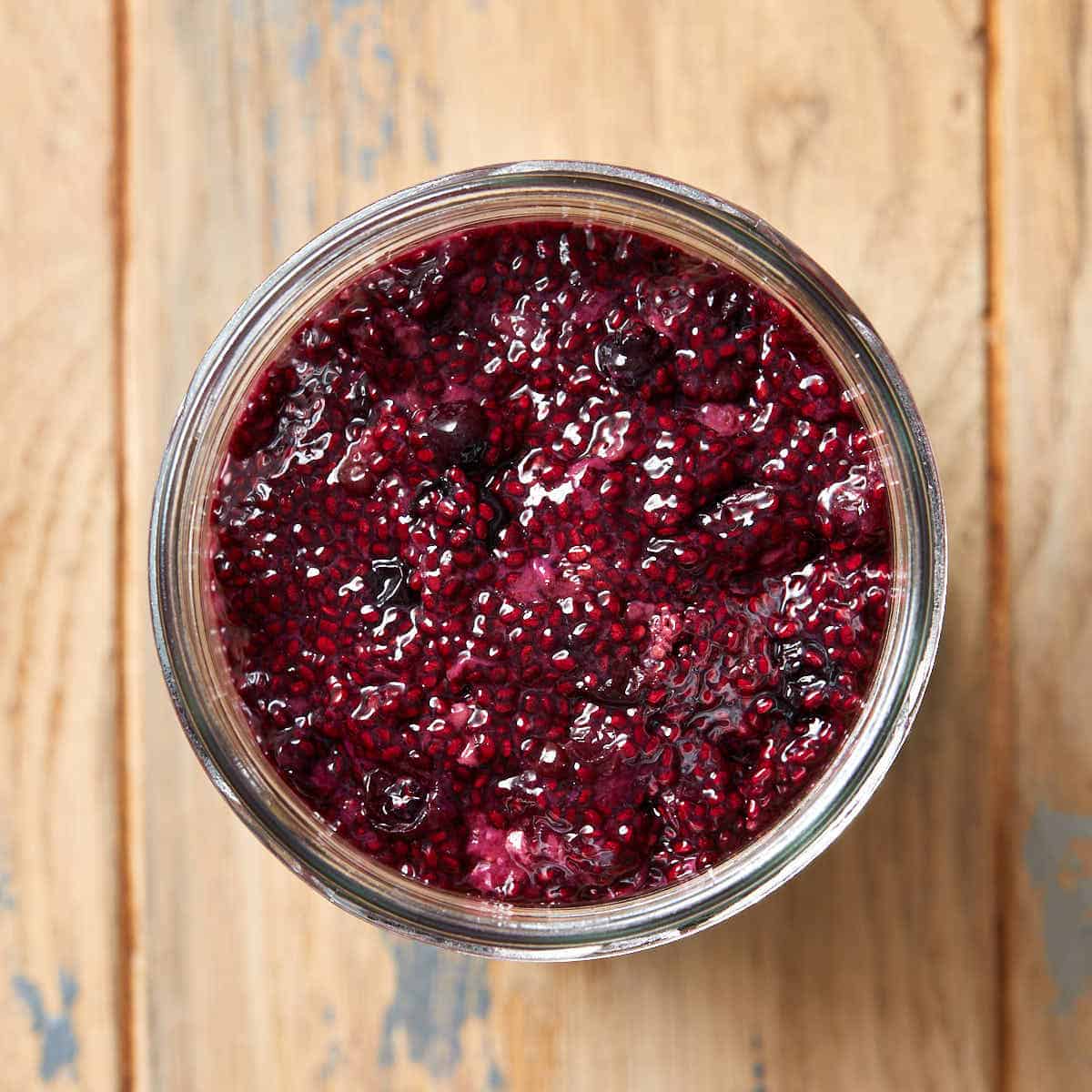 Overhead view of triple berry chia seed jam in a glass jar.
