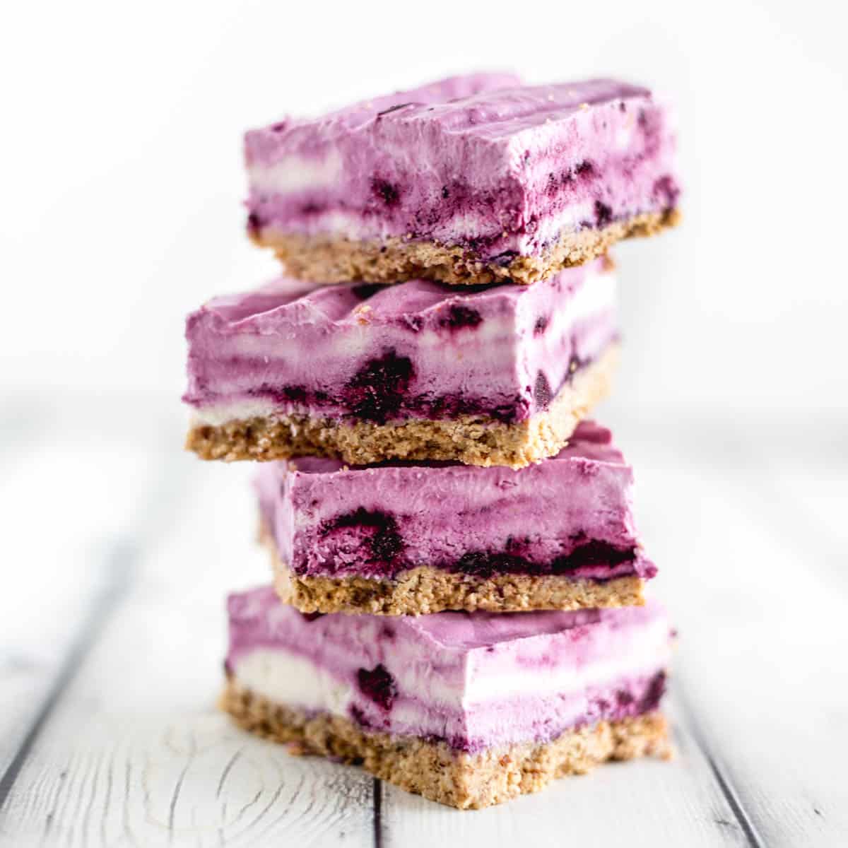 Side view of 4 blueberry frozen yogurt bars stacked on top of each other.