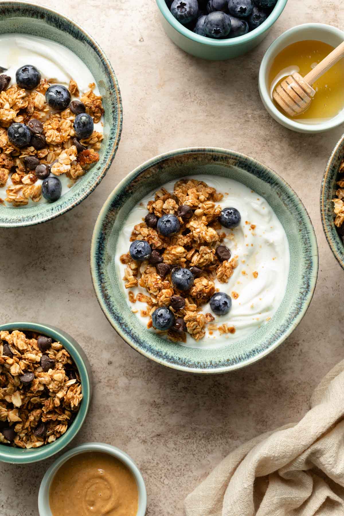 Overhead view of yogurt in green bowls with granola on top.