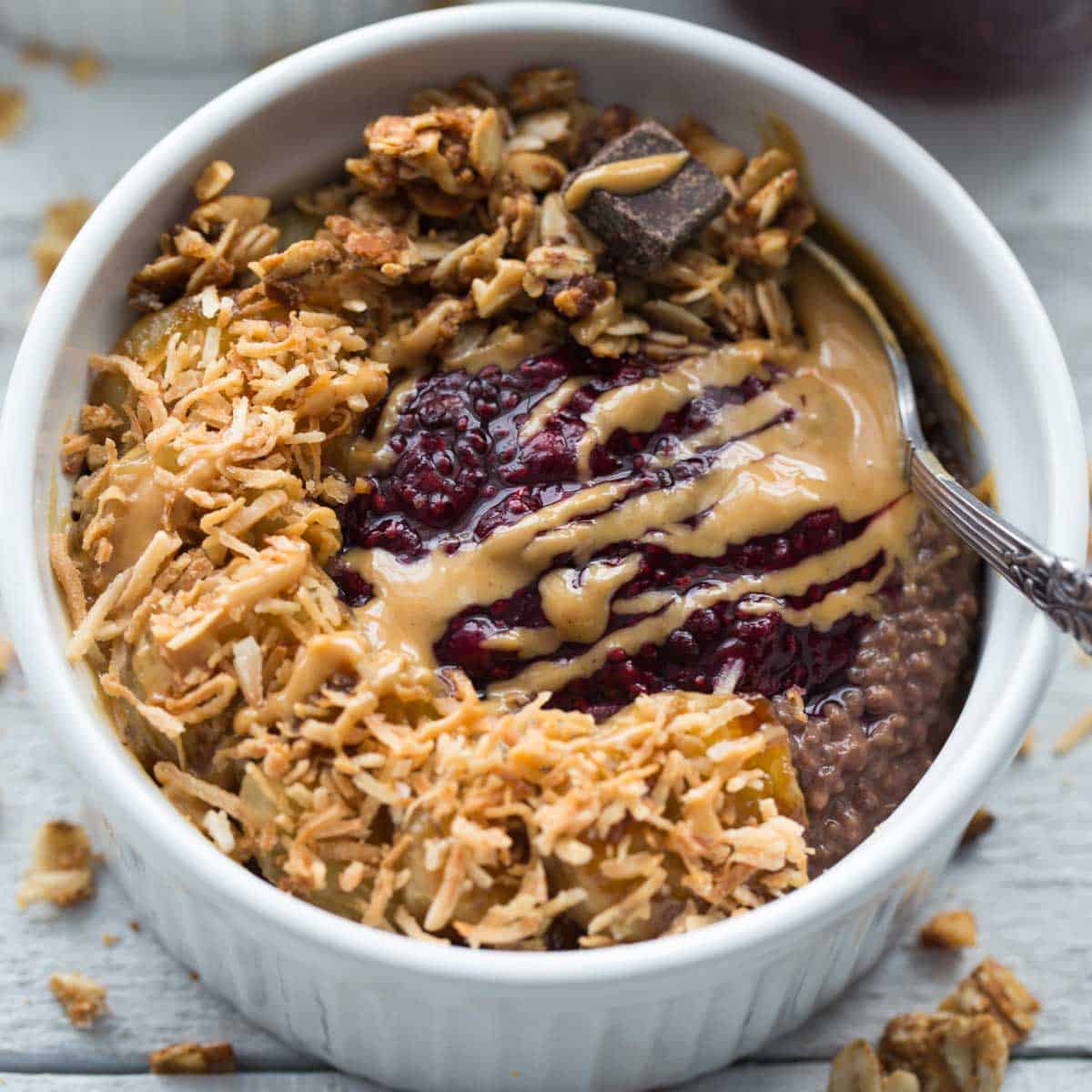 Overhead of chocolate peanut butter chia pudding in a small white bowl with a spoon.