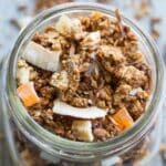 Overhead close up of cashew granola in a wide mouth glass jar.