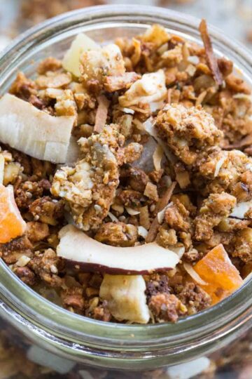 Overhead close up of cashew granola in a wide mouth glass jar.
