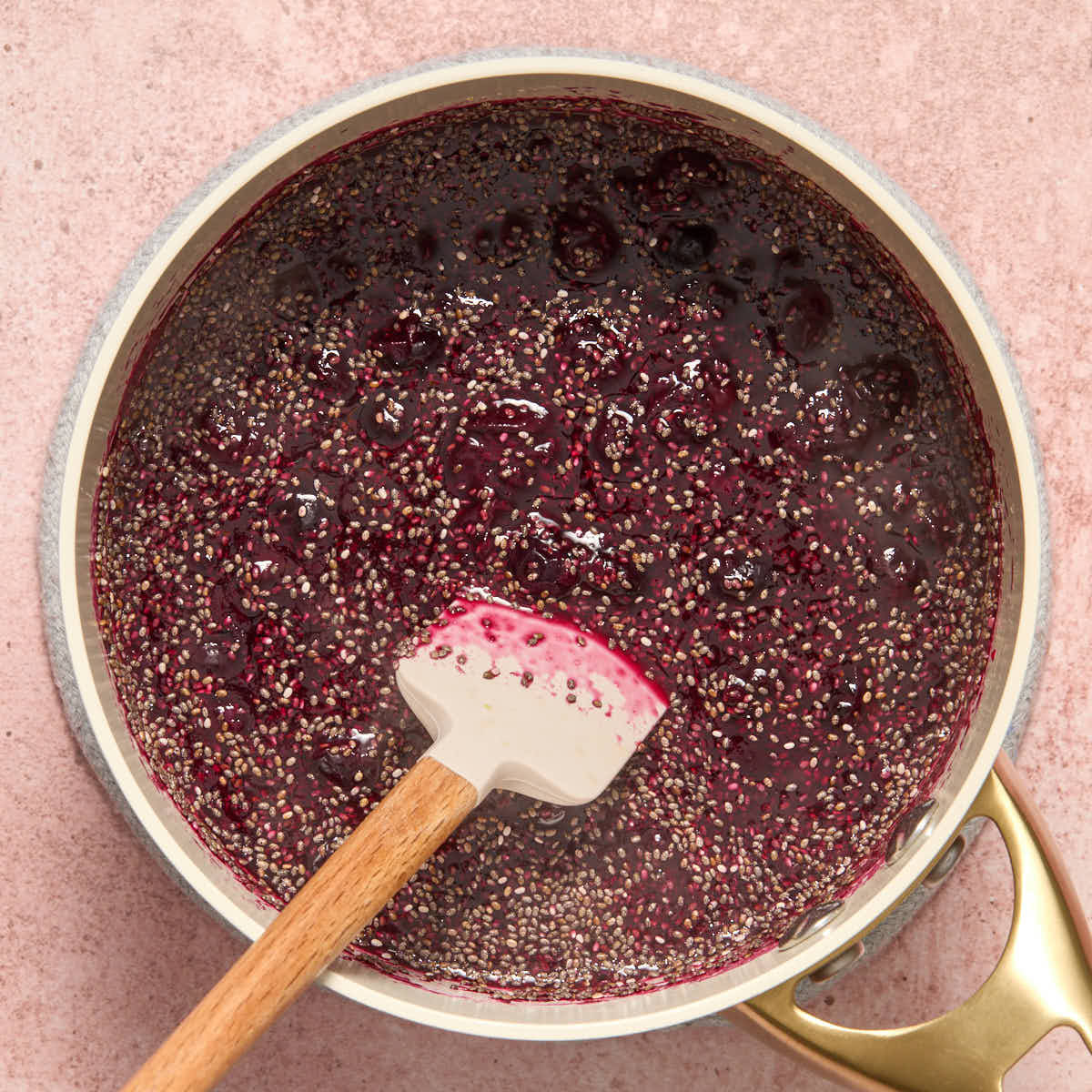 Chia seeds stirred into the cooked blueberries with a spatula.