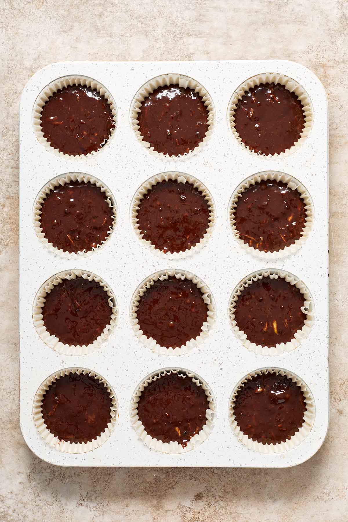 Cupcake batter divided into a muffin pan.