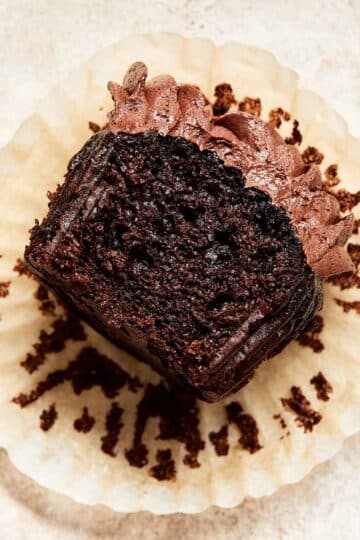 Close up view of a chocolate zucchini cupcake with a bite taken out of it.
