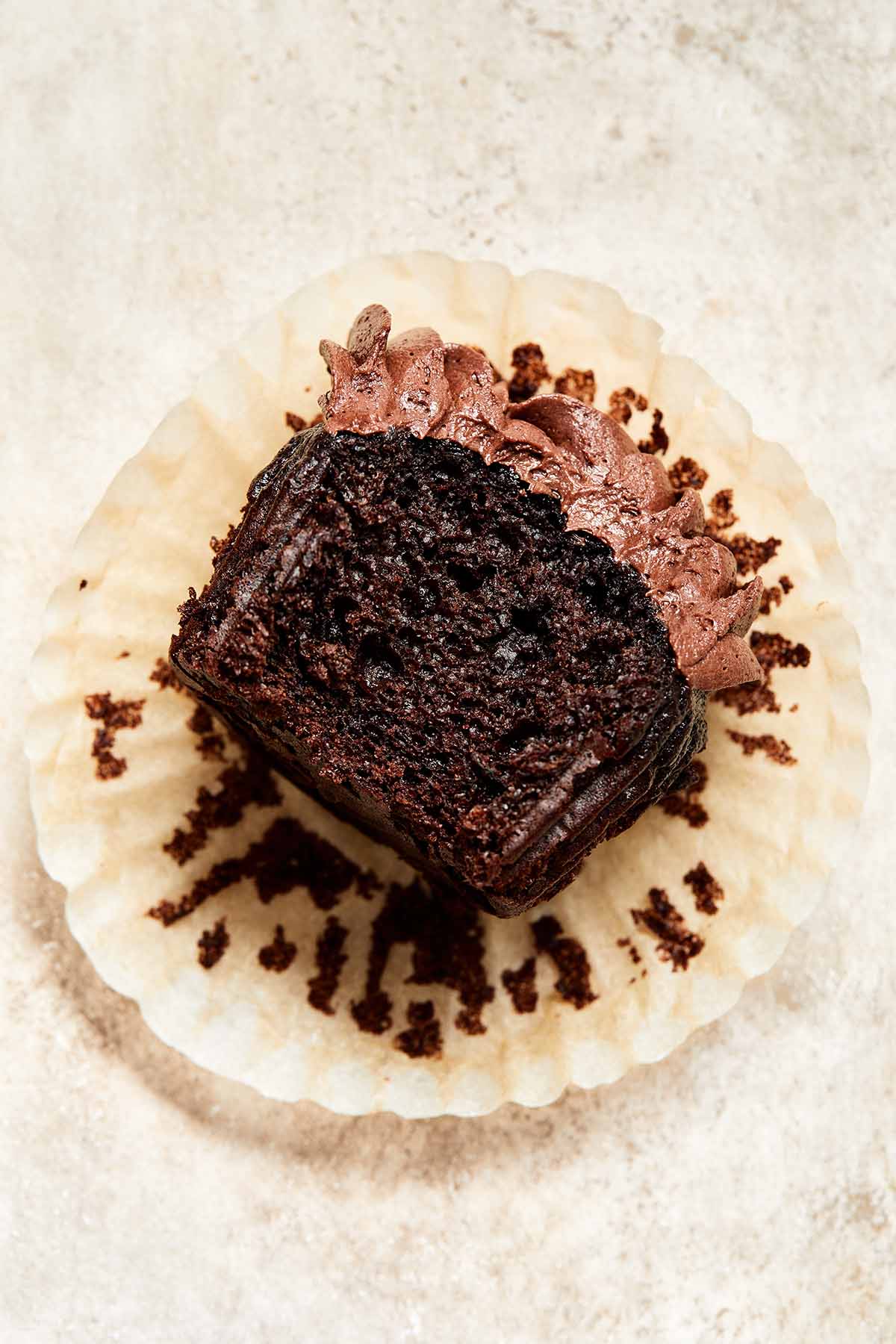 Chocolate cupcake on a cupcake wrapper with a bite taken out of it.