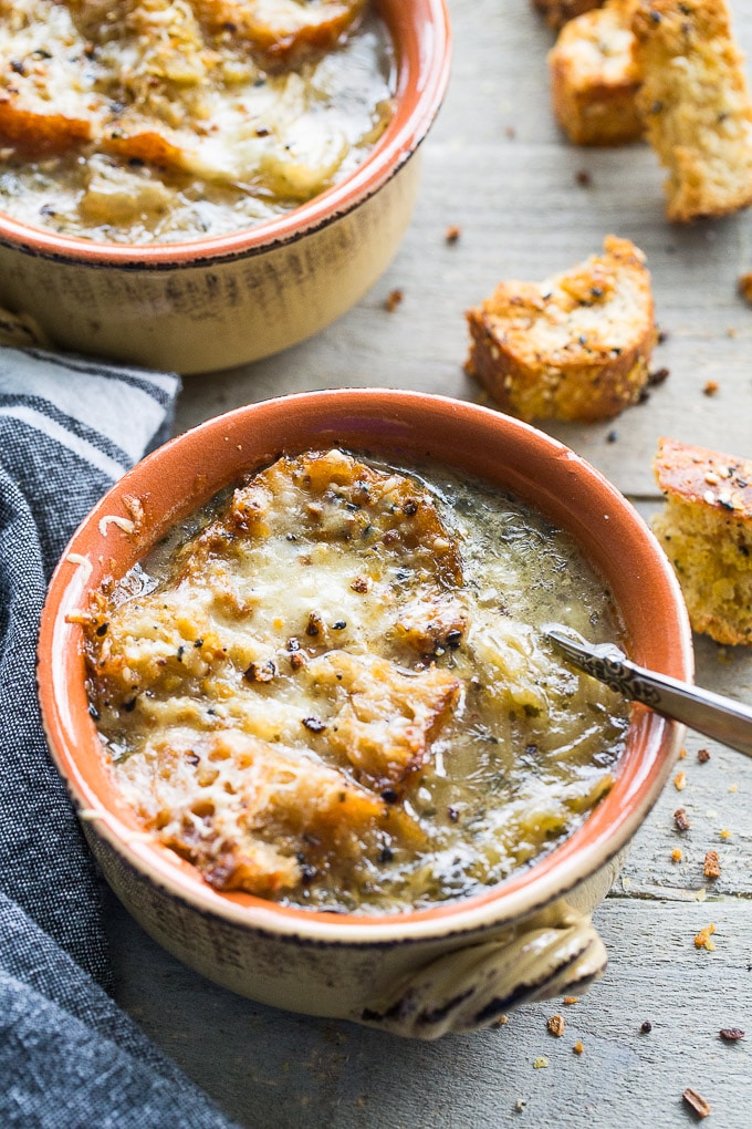 Up close view of Easy Bone Broth French Onion Soup in an orange bowl.