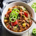 Close up of Instant Pot vegan chili in a white bowl with a spoon.