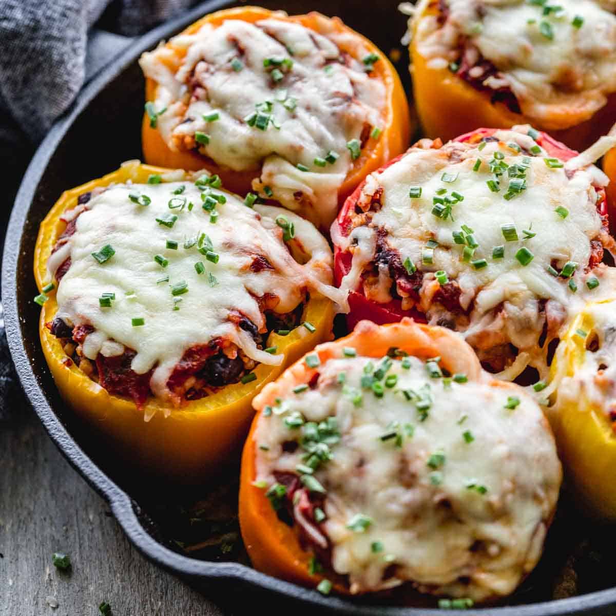 Close up view of stuffed vegetarian peppers in a cast iron skillet.