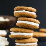 Side view of four Chewy Ginger Cookies with Lemon Cream Cheese Frosting stacked on top of each other.