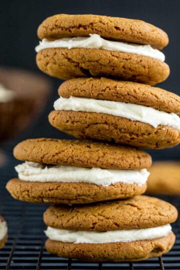 Side view of a stack of four chewy ginger sandwich cookies.