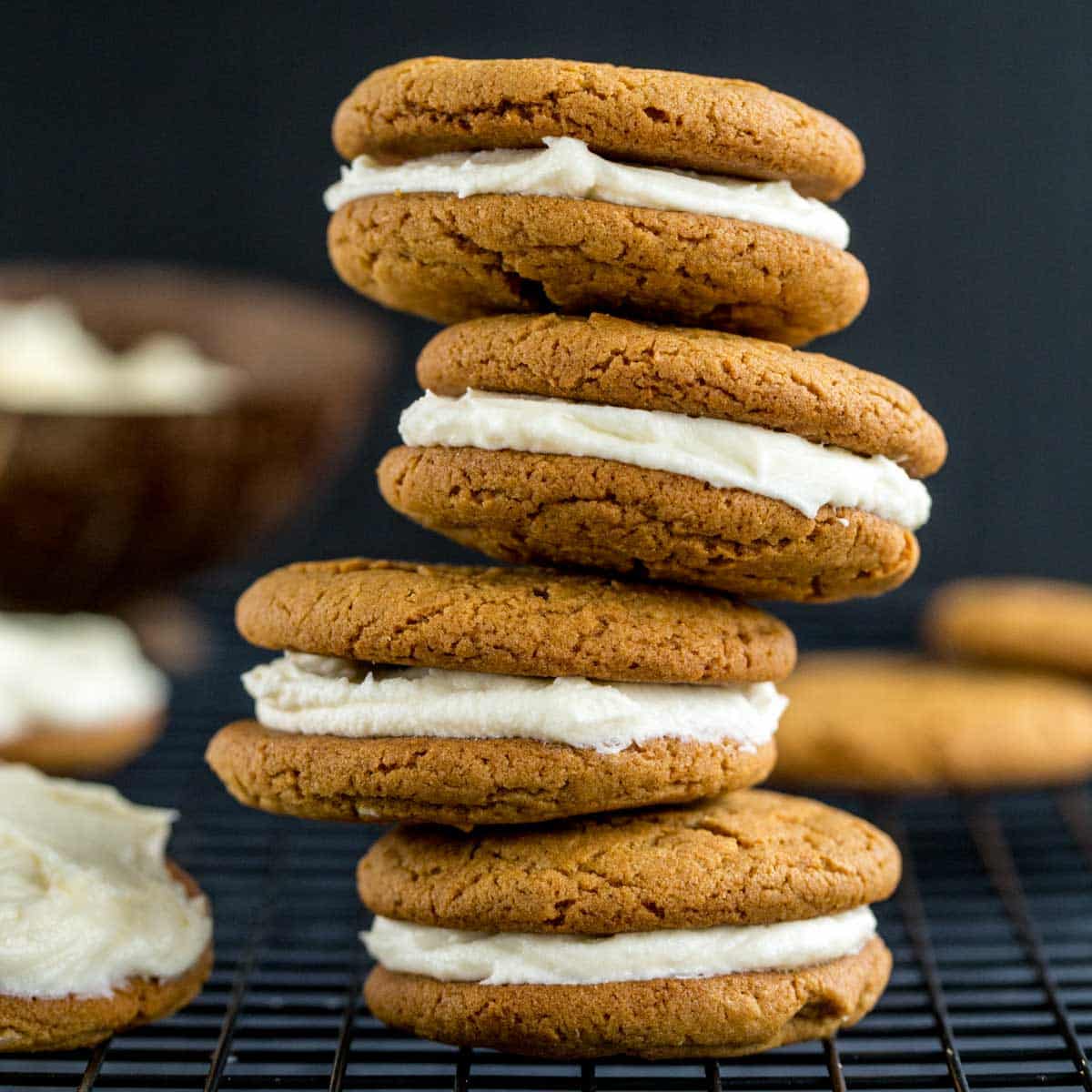 Side view of a stack of four chewy ginger sandwich cookies.
