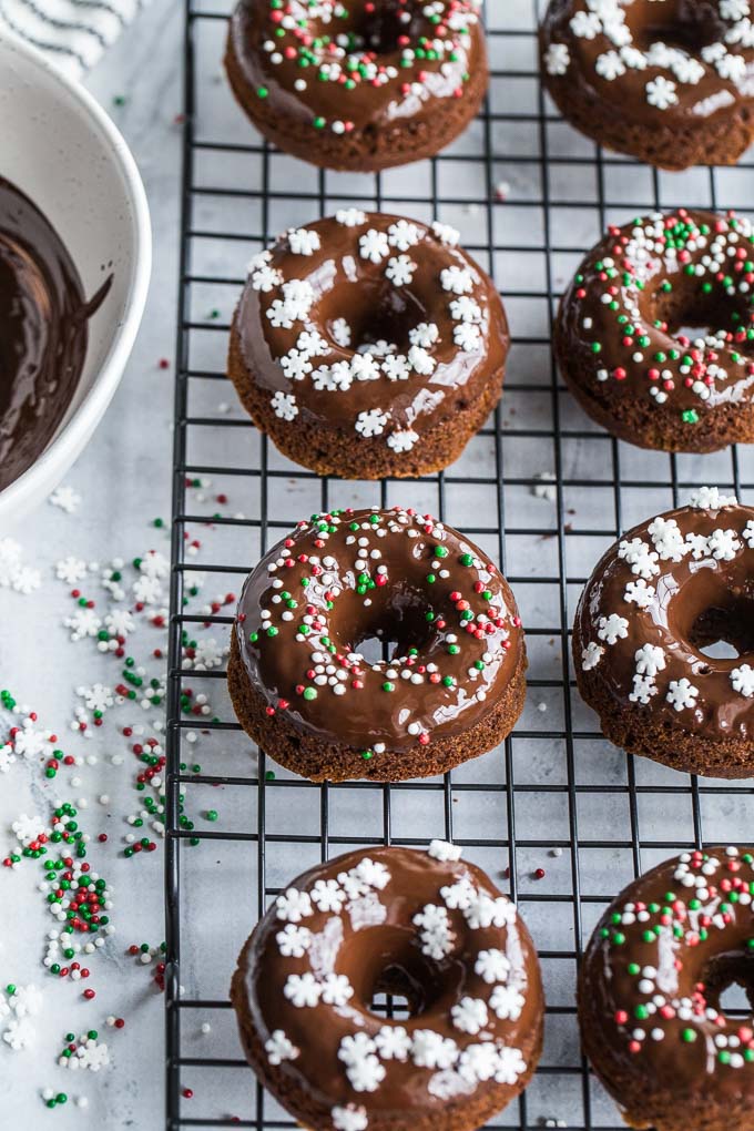 Overhead view of Mini Gingerbread Protein Donuts with Chocolate Glaze on a wire rack.