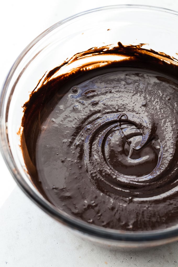 Up-close view of melted dark chocolate and tahini in a glass bowl.