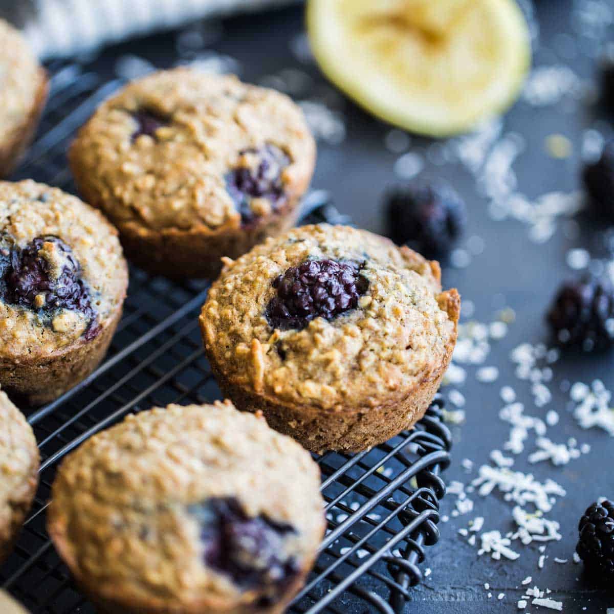 Angled view of blackberry lemon muffins on a round wire rack.