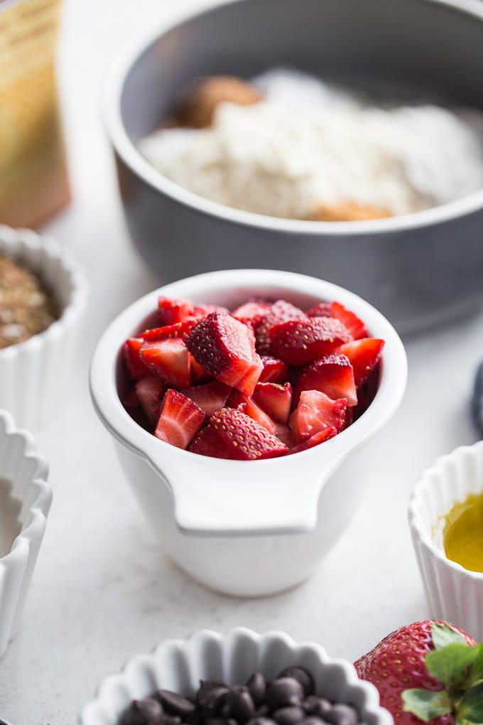 Up-close view of chopped strawberries in a white cup.
