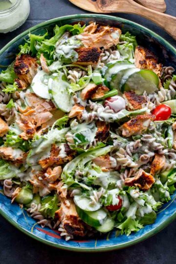 Overhead of salmon pasta salad served in a large blue bowl.