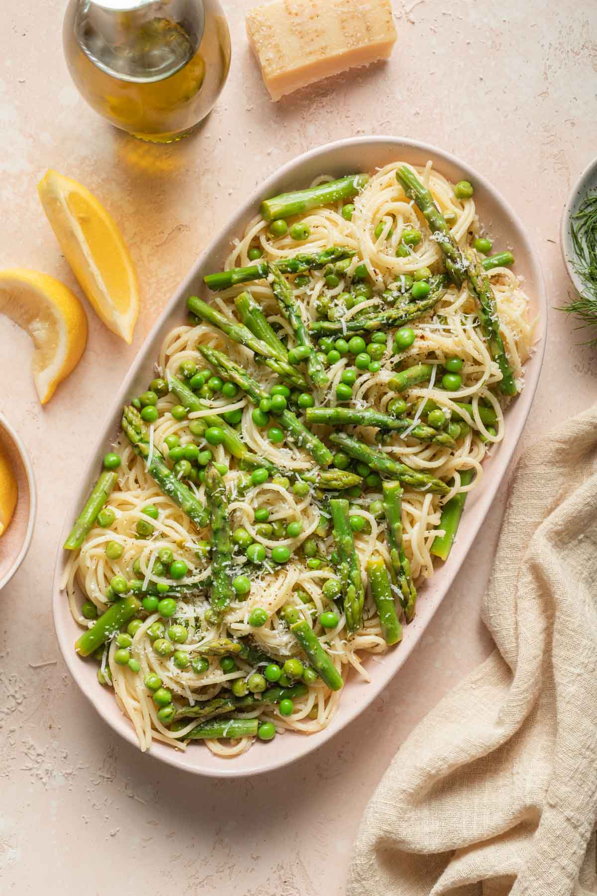 Overhead view of asparagus and pea pasta on an oval platter.