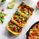Overhead of 3 tofu scramble breakfast tacos in a taco stand.