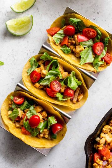 Overhead of 3 tofu scramble breakfast tacos in a taco stand.