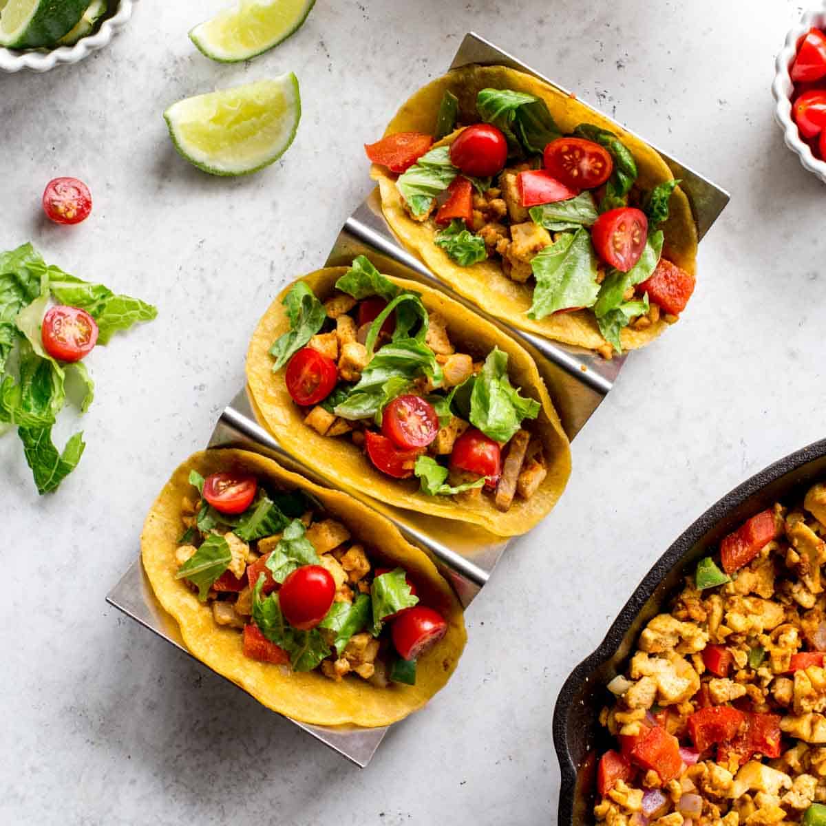 Overhead of 3 tofu scramble breakfast tacos in a taco stand.