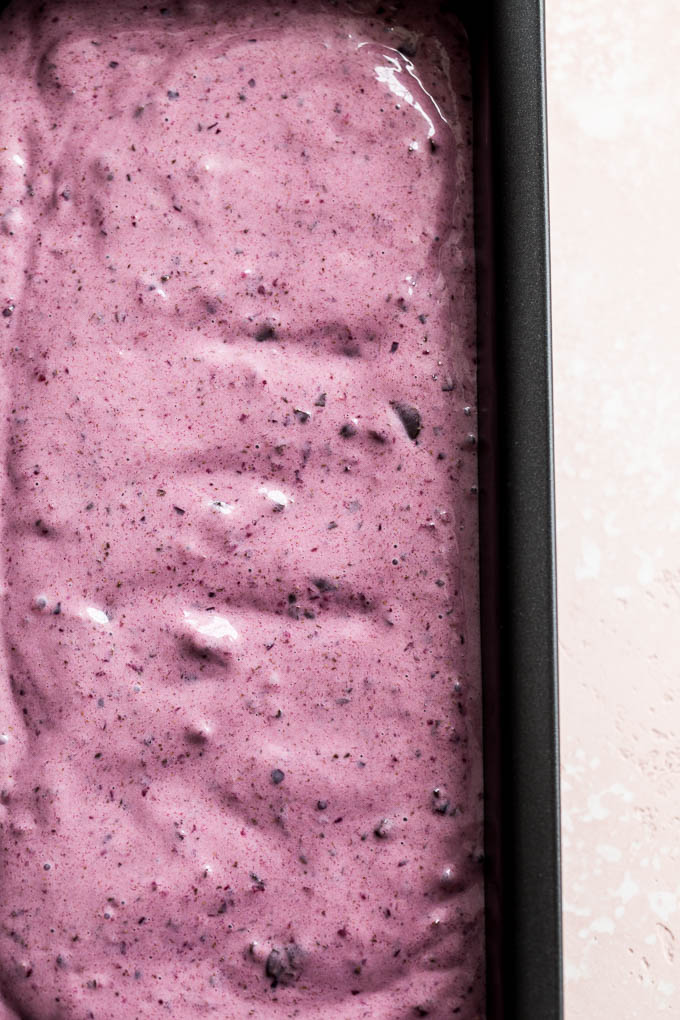 Up-close view of vegan cherry ice cream spread out in a loaf pan.