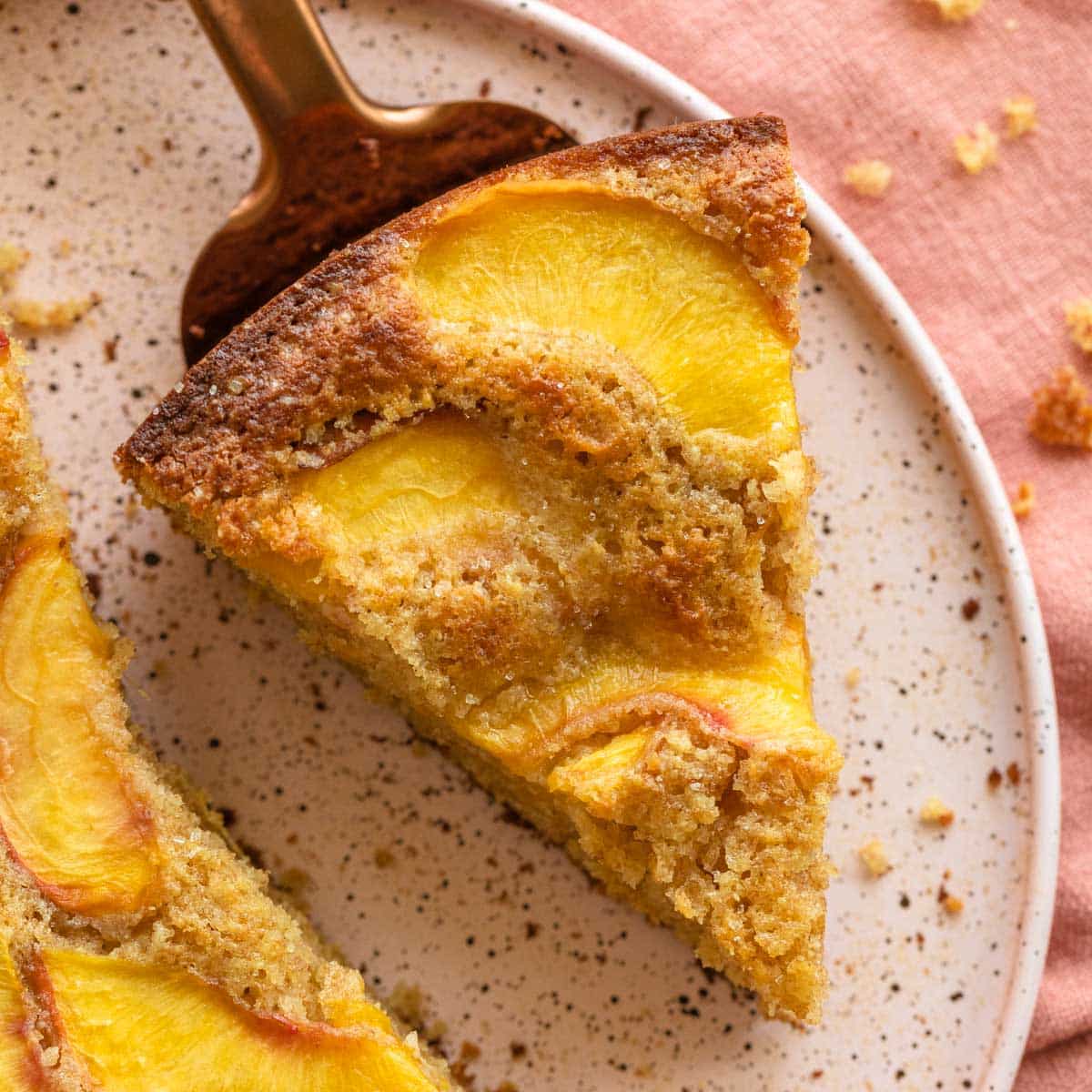 Slice of peach cake on a pink plate.
