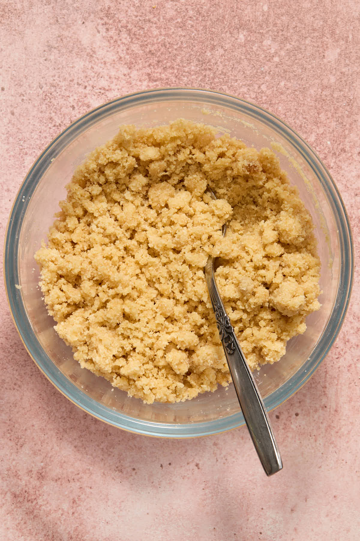 Crumb topping mixed together in a glass bowl with a fork.