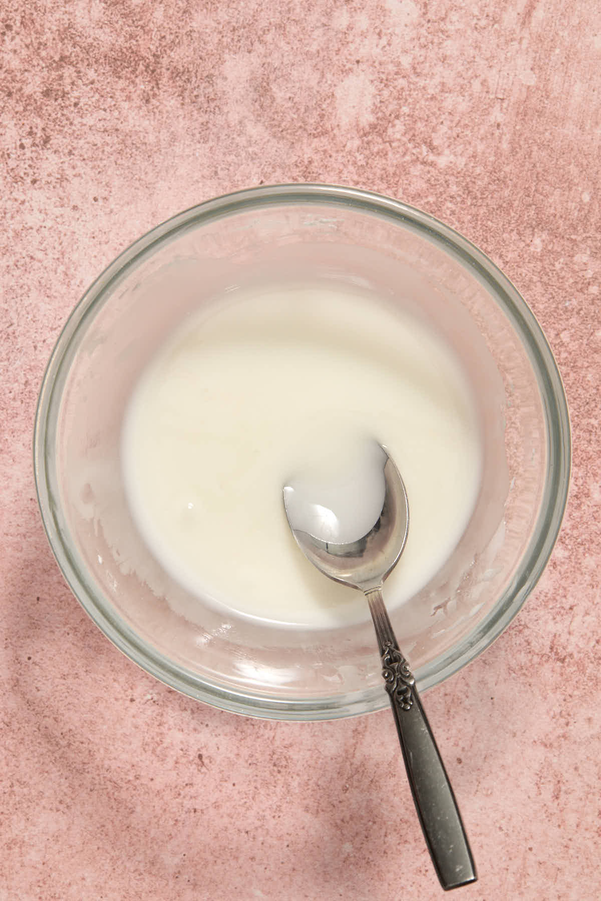 Powdered sugar glaze mixed together in a small bowl with a spoon.