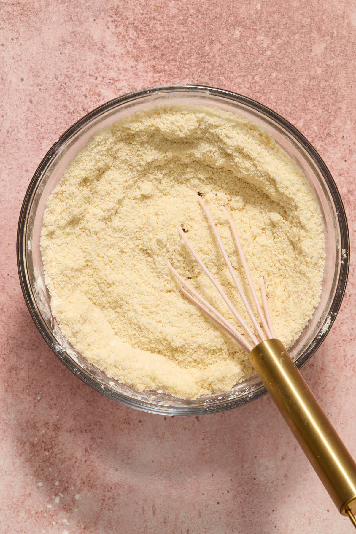 Dry ingredients for cake batter whisked together in a glass bowl.