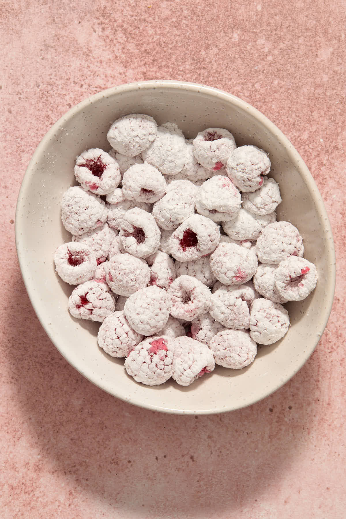 Raspberries tossed with cornstarch in a white bowl.