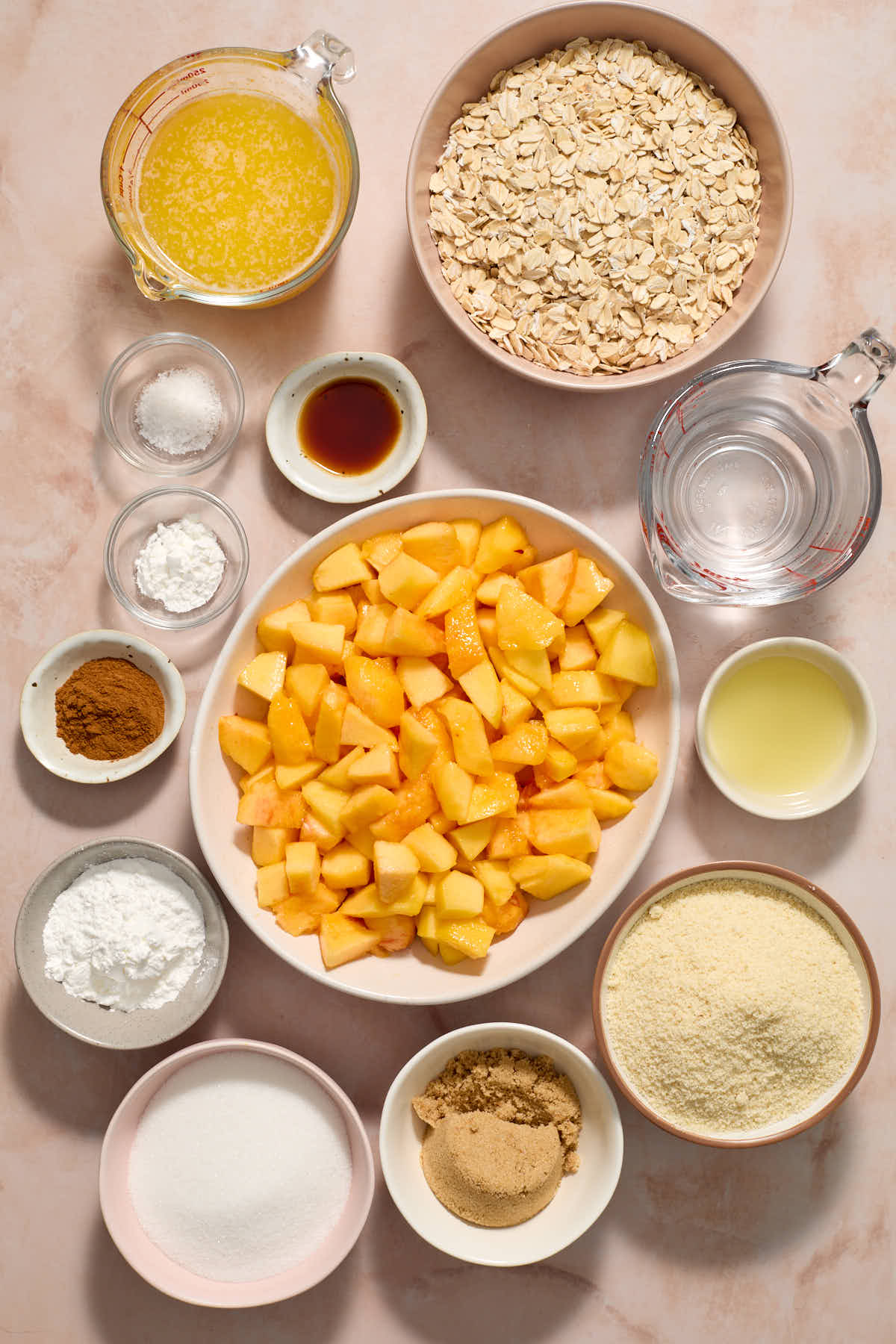 Ingredients to make almond flour peach bars arranged in separate bowls and measuring cups.