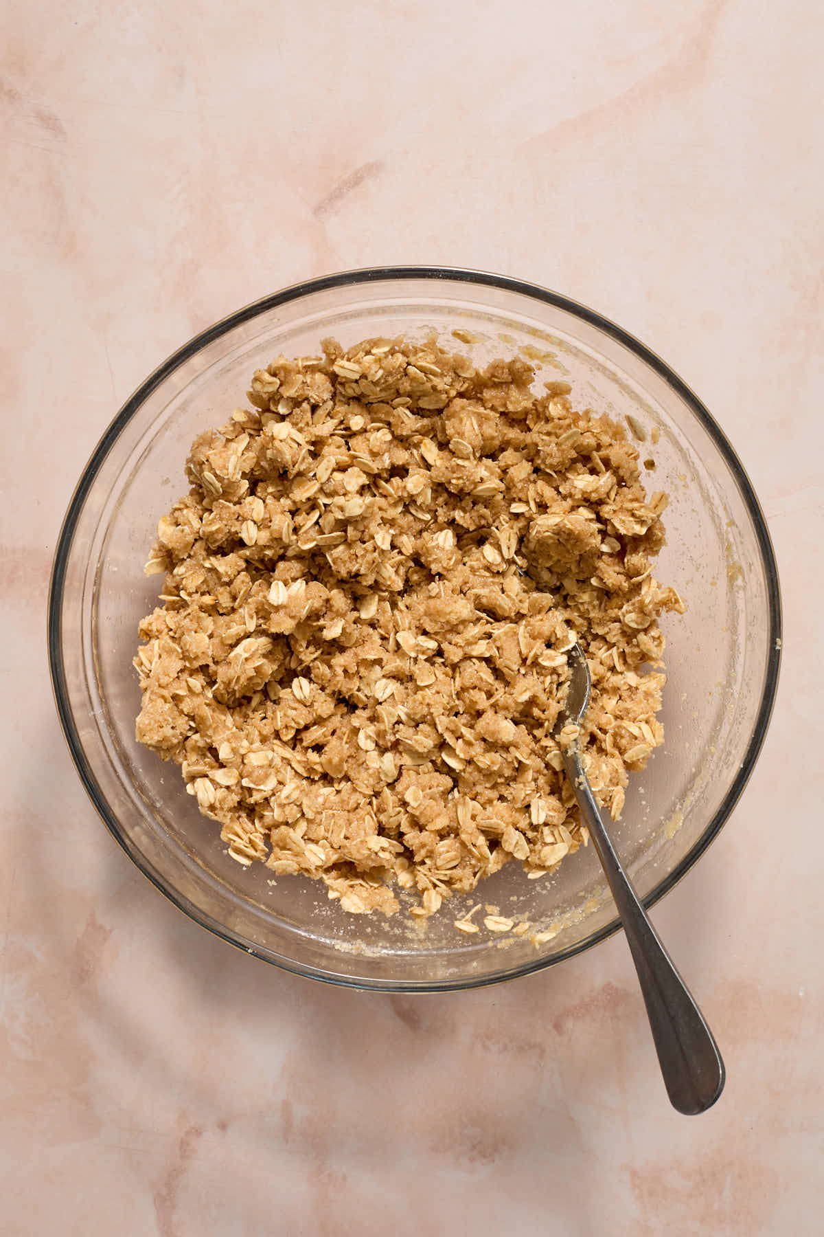 Oat mixture mixed together in a glass bowl with a fork.