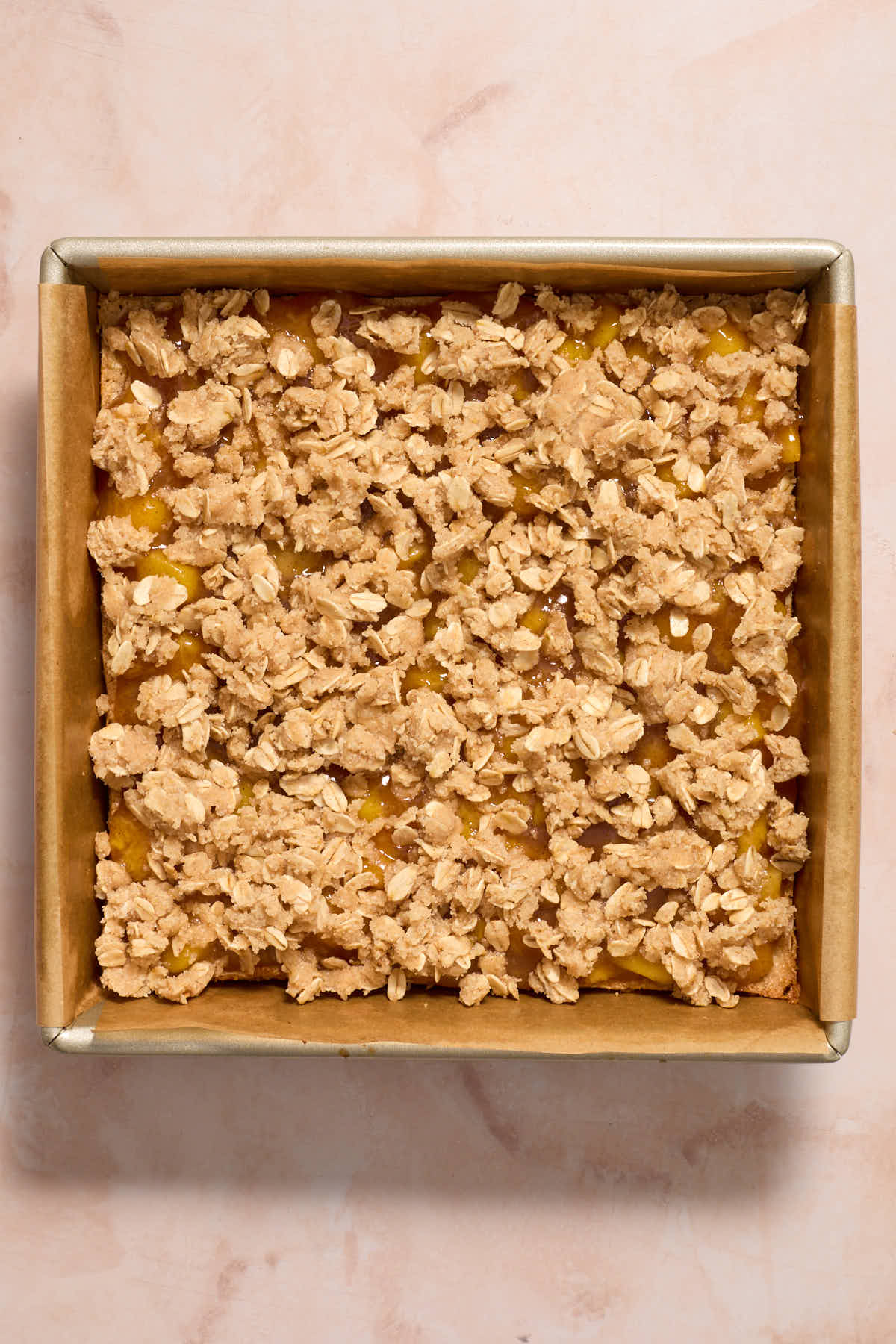 Peach filling and crumble topping layered on top of the crust.