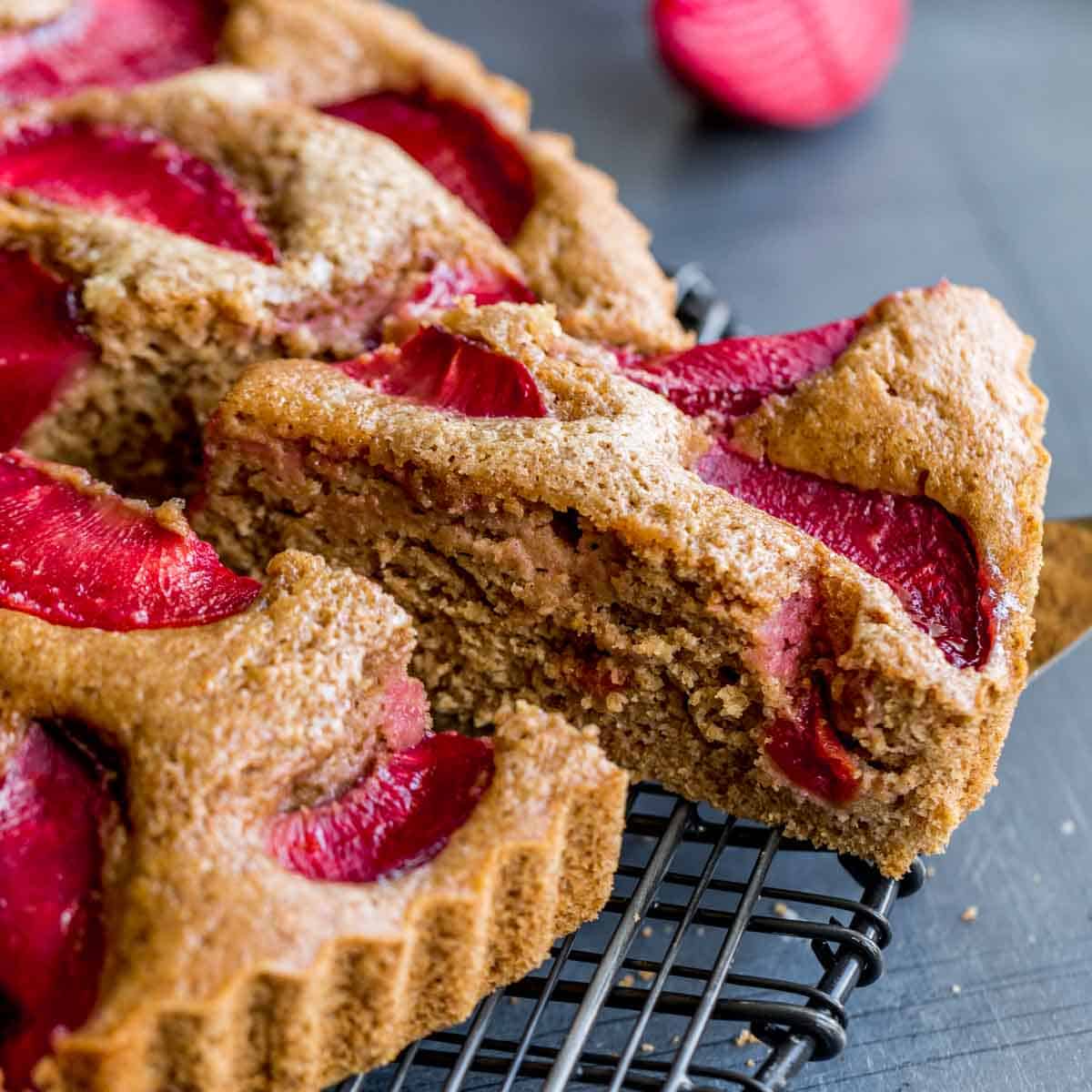 Side view of a slice of buttermilk plum cake being removed.