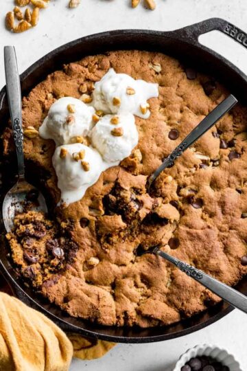 Overhead of chocolate chip pecan skillet cookie in a black cast iron skillet.