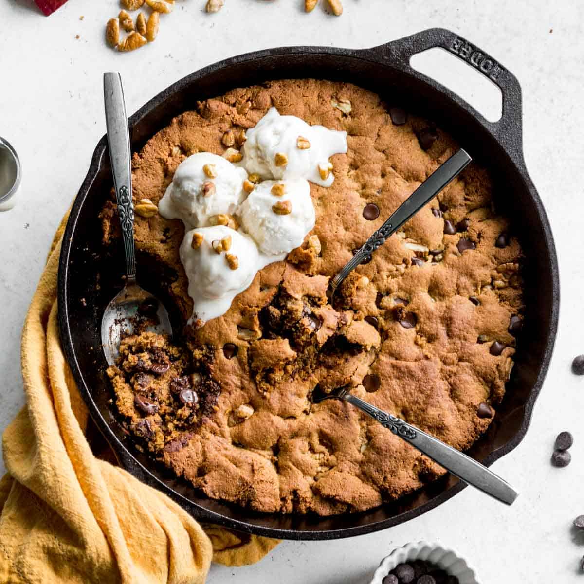 Overhead of chocolate chip pecan skillet cookie in a black cast iron skillet.