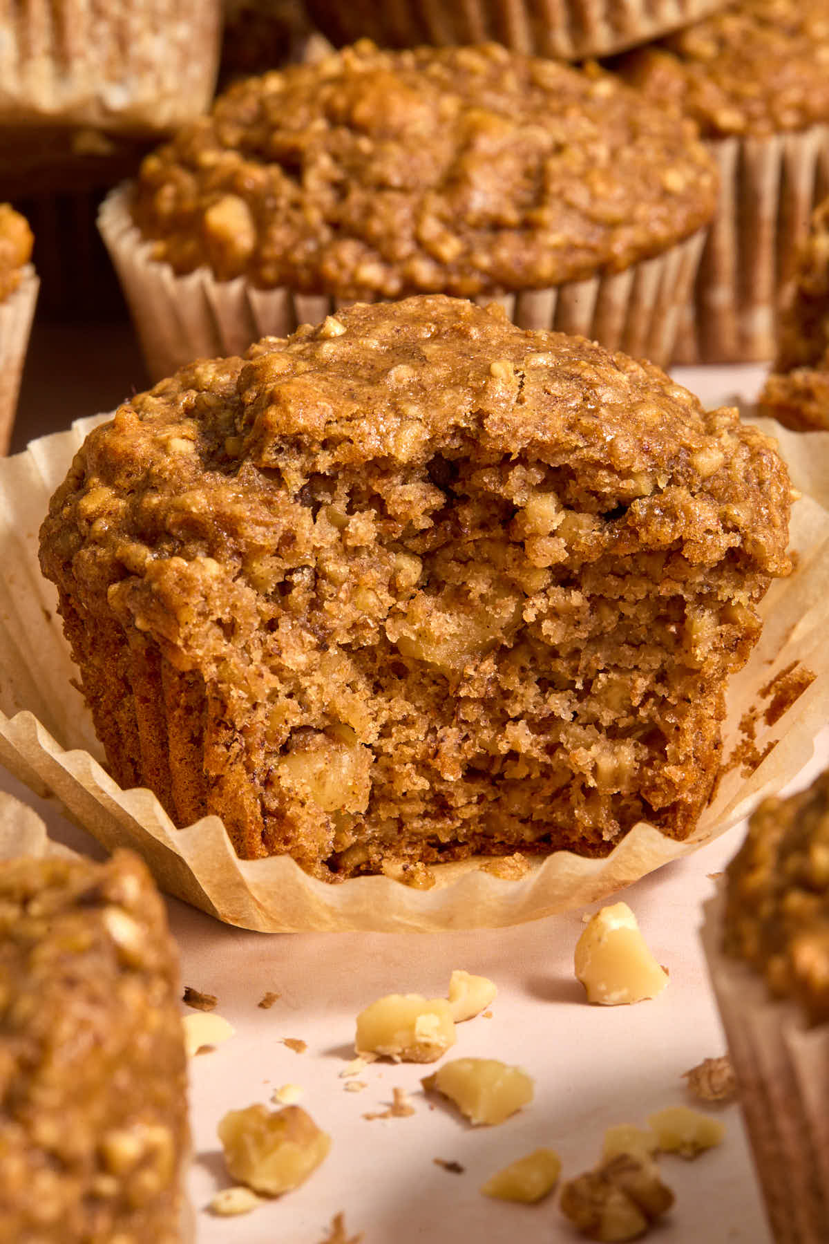Close up of a banana nut muffin with the muffin liner peeled away and a bite taken.