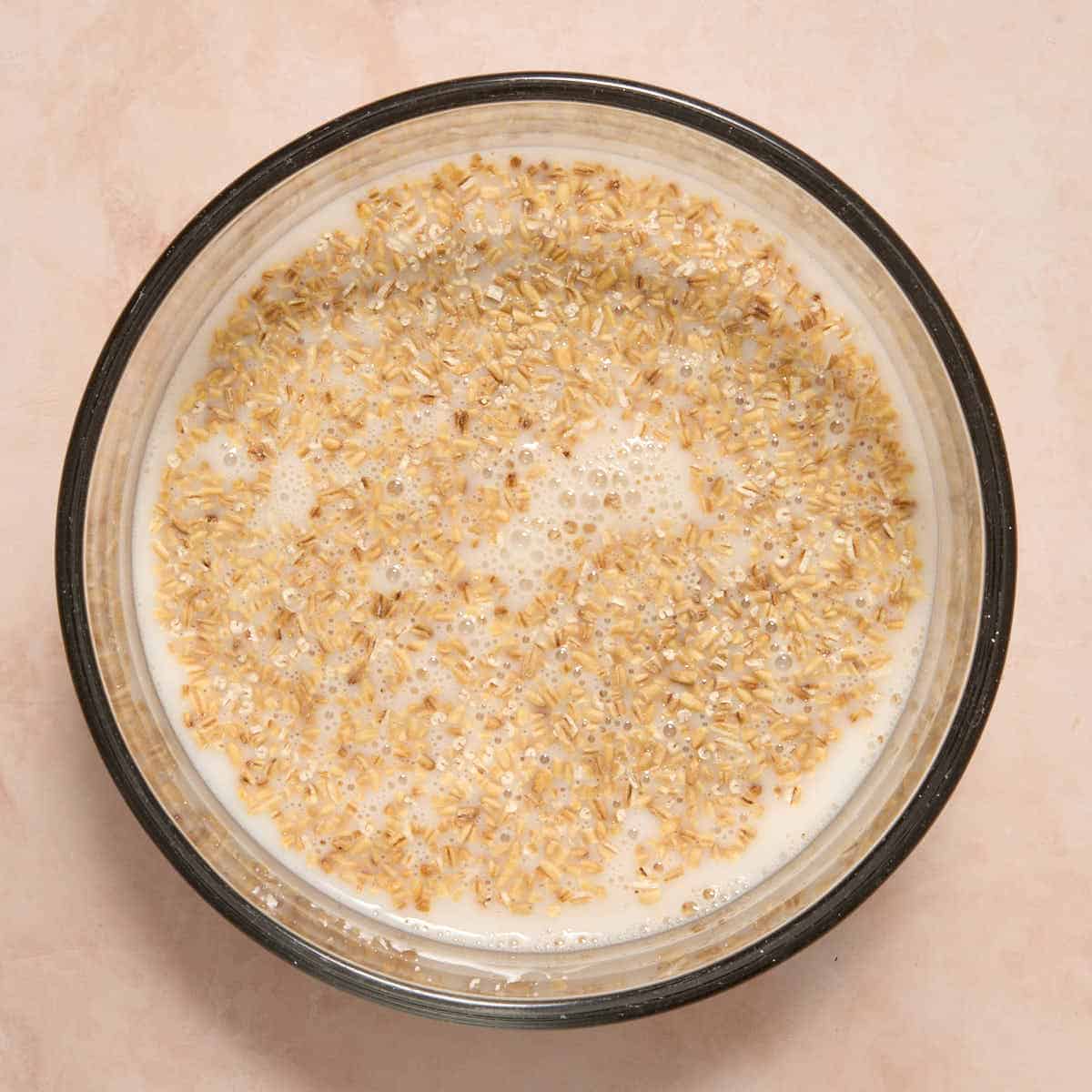 Oats and almond milk combined in a glass bowl (before soaking).