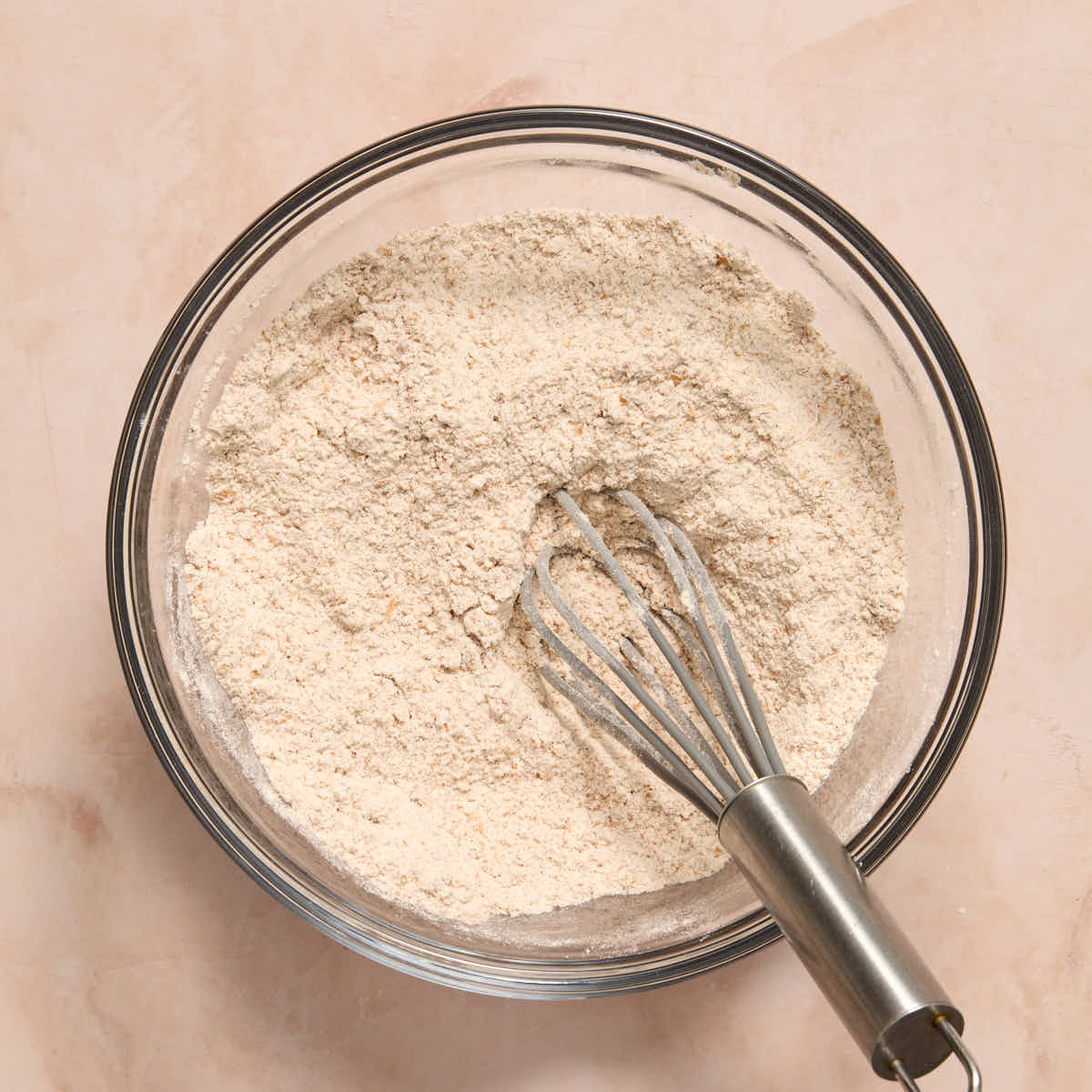 Dry ingredients whisked together in a glass bowl.