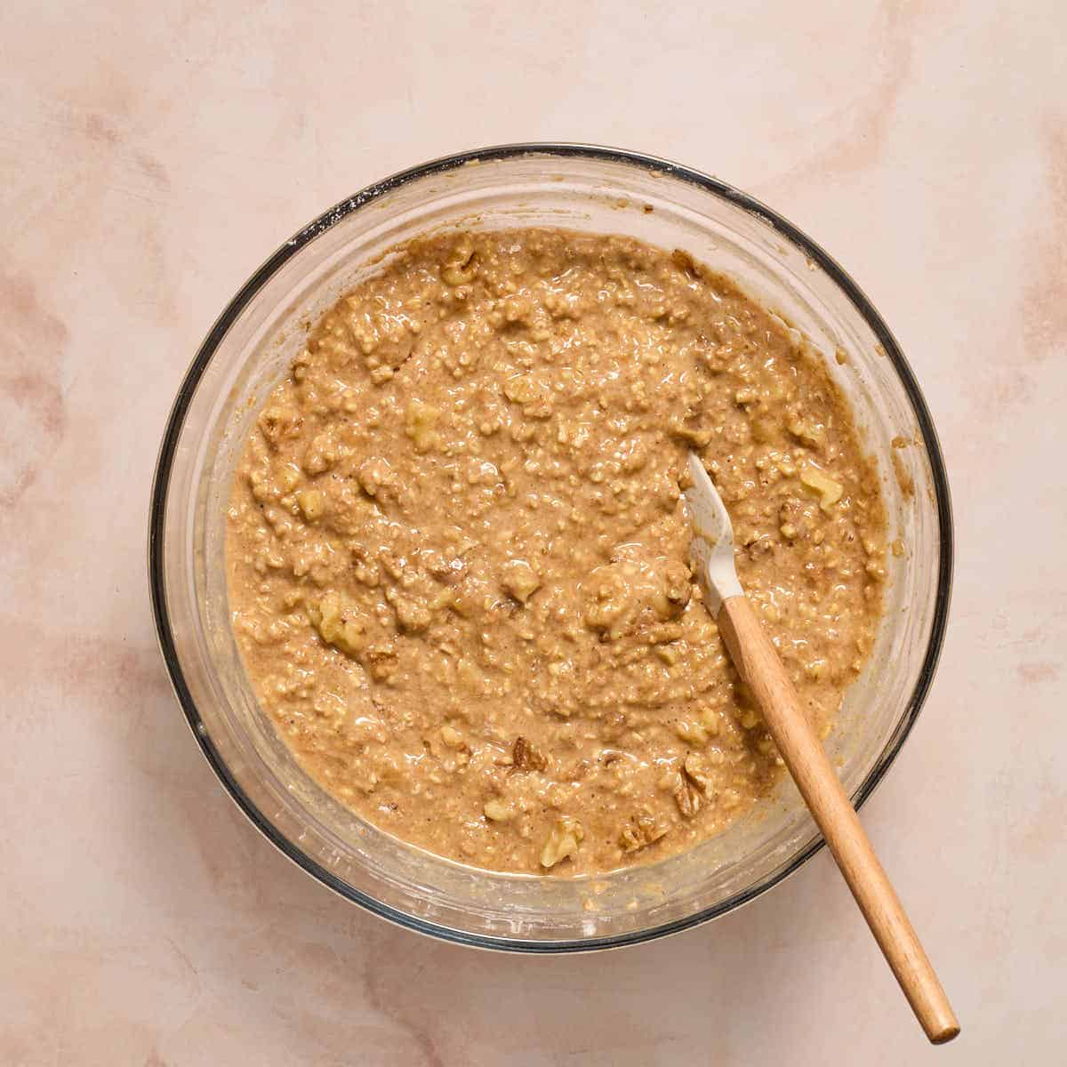 Walnuts mixed into batter with a spatula.