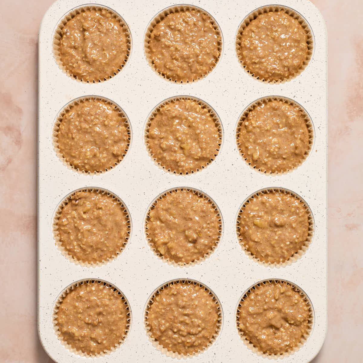 Muffin batter divided into a 12-cup muffin pan.