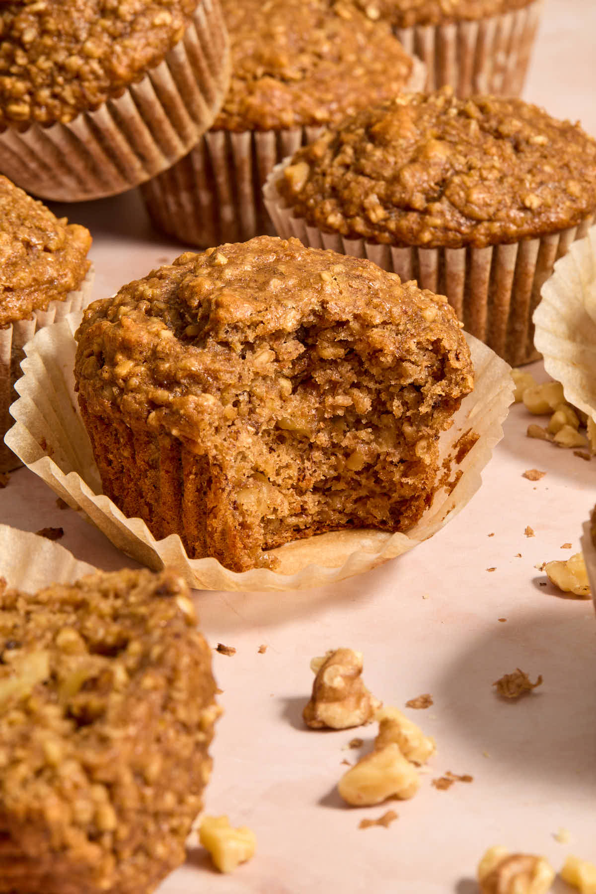 Side view of banana nut muffins and one with a bite taken.