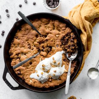 Overhead view of chocolate chip skillet cookie on a white surface.