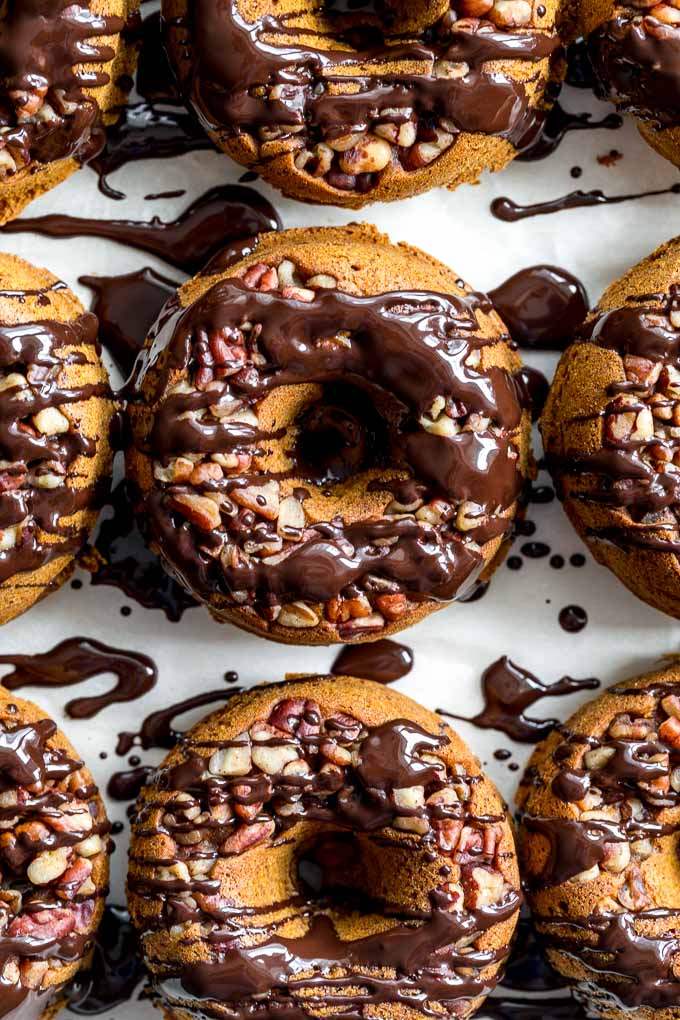 Up-close overhead view of baked pumpkin donuts with melted chocolate on top.