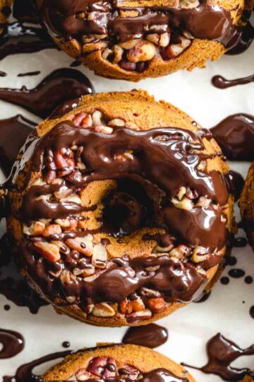 Close up overhead of pumpkin spice donuts with melted chocolate drizzled over them.