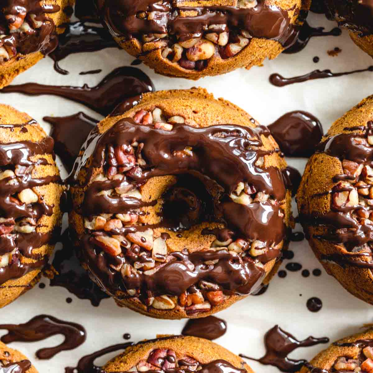 Close up overhead of pumpkin spice donuts with melted chocolate drizzled over them.