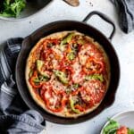 Overhead of homemade pizza in a cast iron skillet.